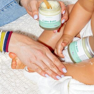 WildMint Calm Balm jar with hands and child's feet