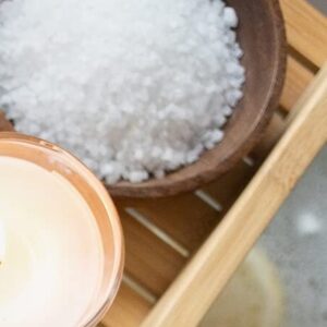 Magnesium bath flakes with a wooden bath tray and towels
